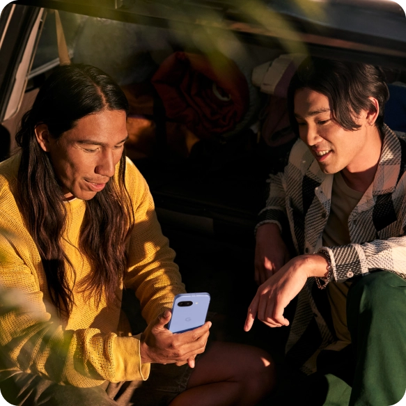 Two friends looking at a Google Pixel 9a